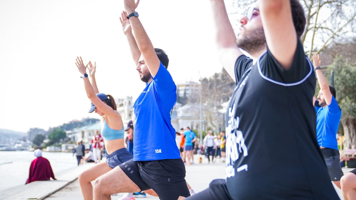 Group performing yoga outdoors along the scenic waterfront in İstanbul, Türkiye.